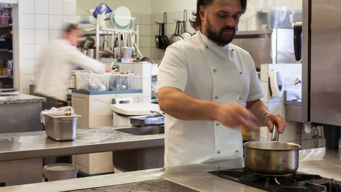 A chef preparing food at Hotel de l'Ange