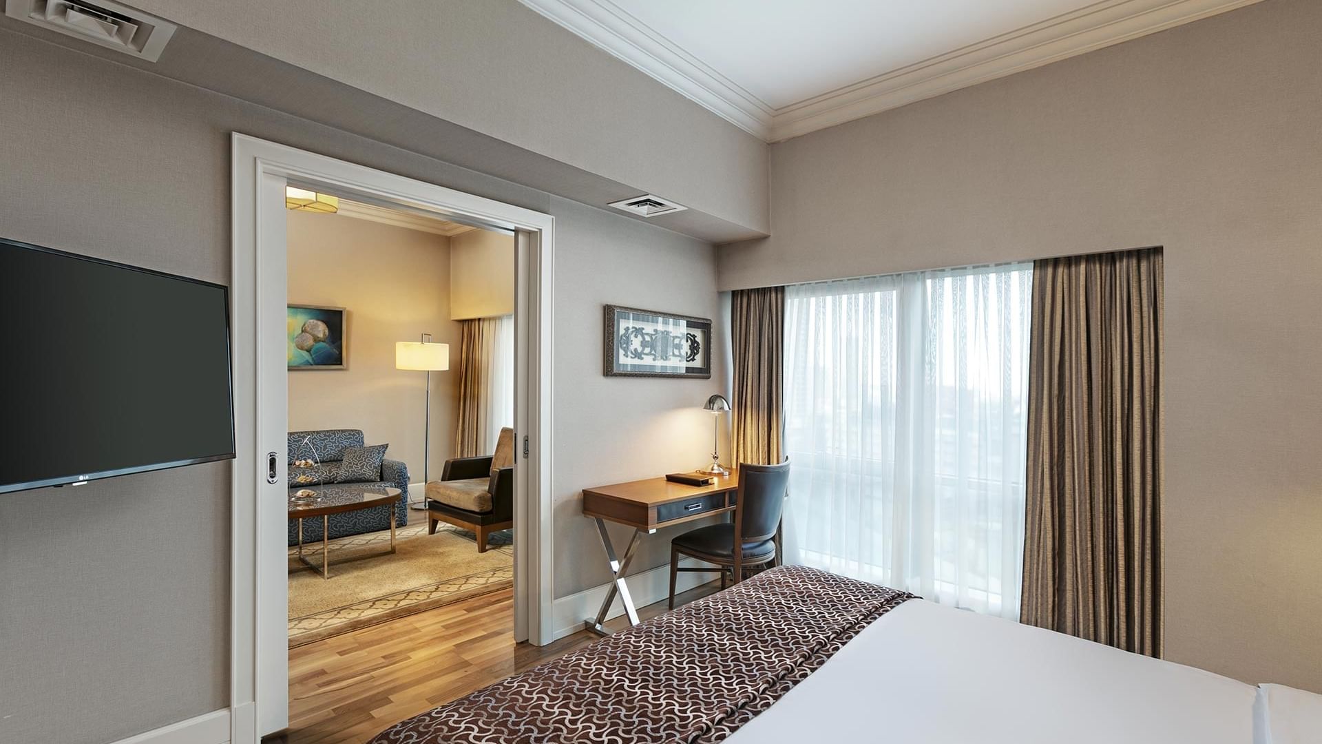 Comfy bed and work desk arranged by the window in Club Suite at Titanic Business Kartal