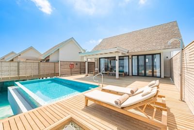 Modern villa at Ananea Madivaru Maldives with a private pool, wooden deck, and sun loungers, set against a bright blue sky