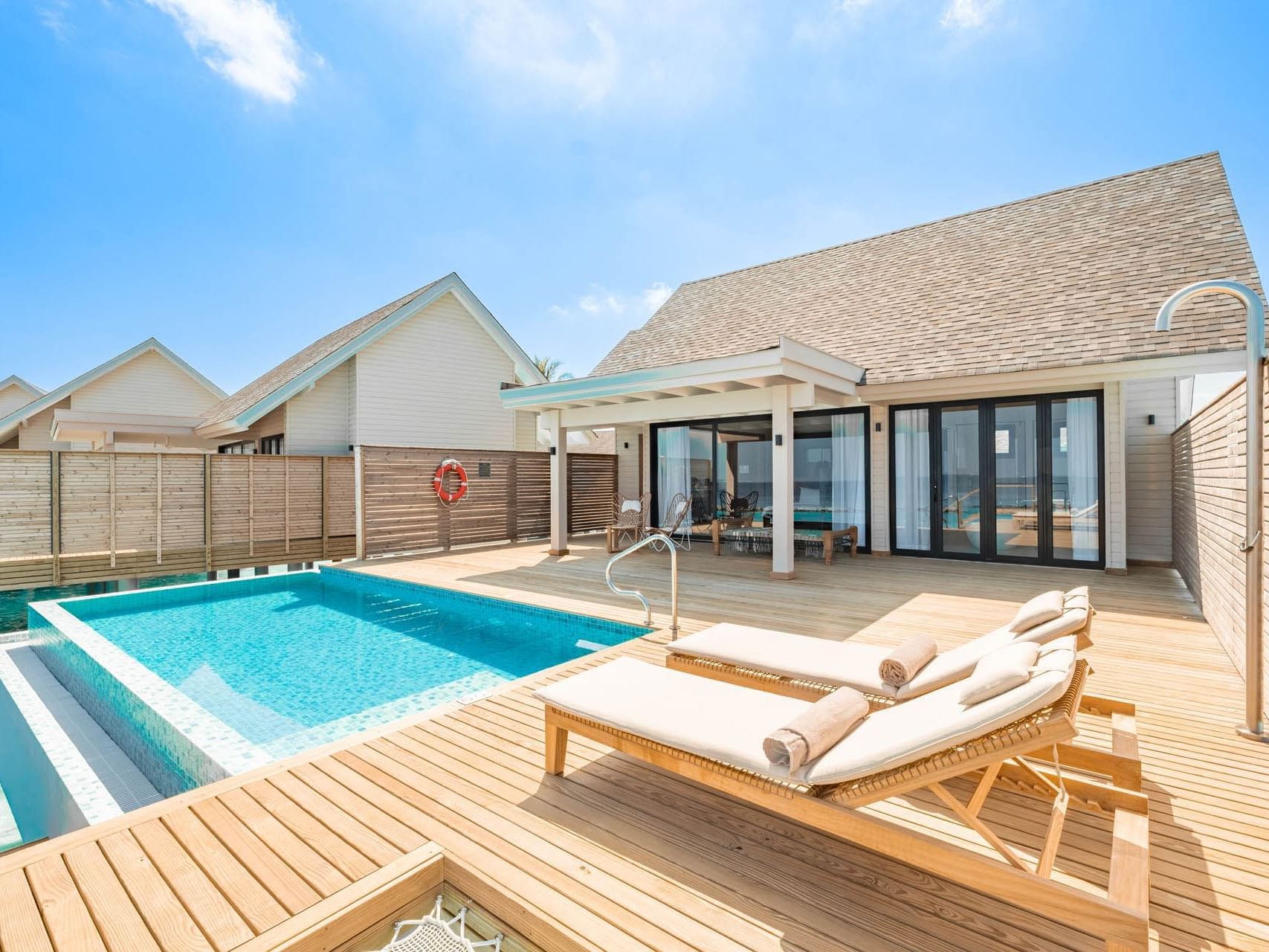 Exterior view of Water Pool Villa with wooden deck and sun loungers at Ananea Madivaru Maldives