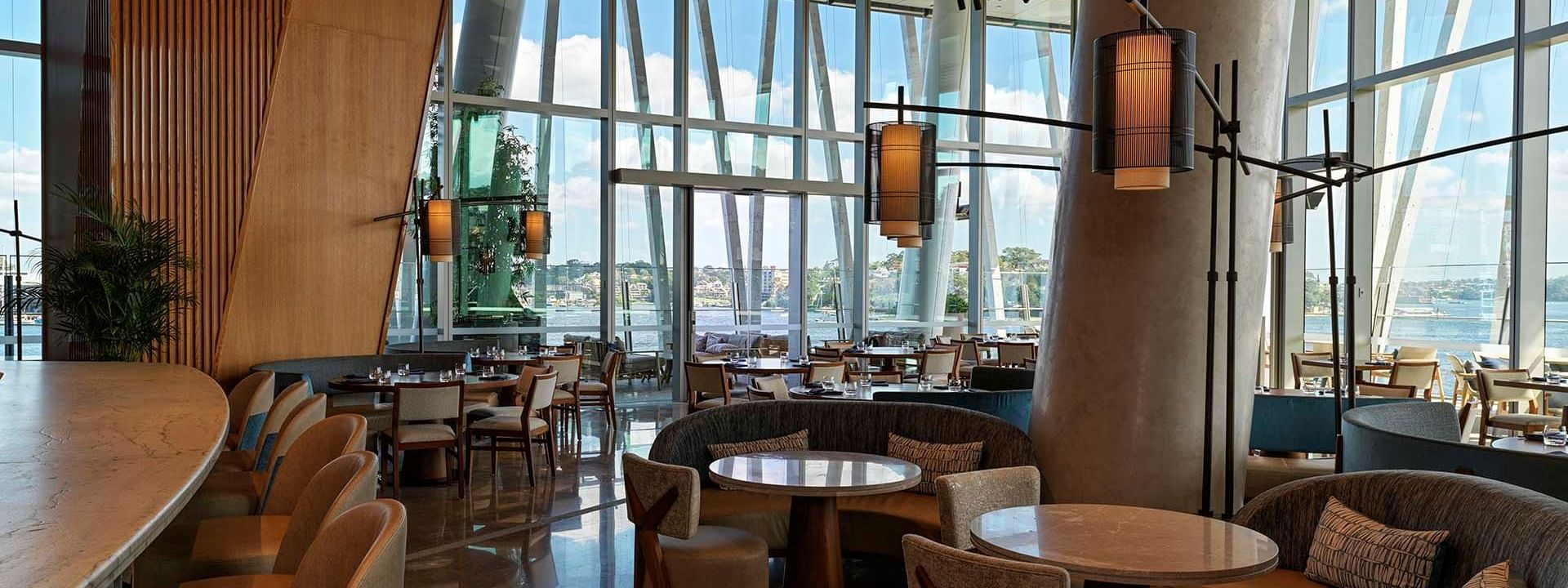 Modern restaurant interior of Nobu with large windows and wooden ceiling at Crown Hotels