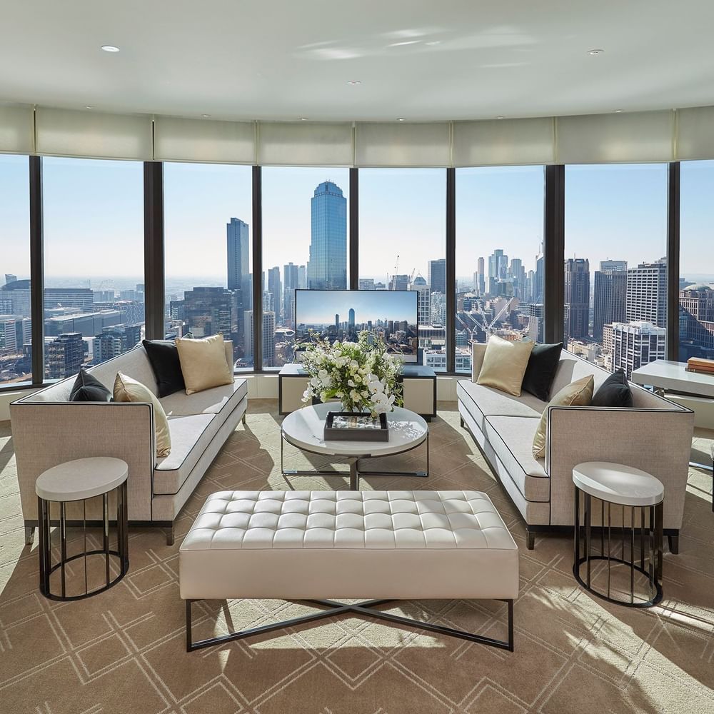 Spacious lounge area with a TV overlooking the city at Crown Hotels