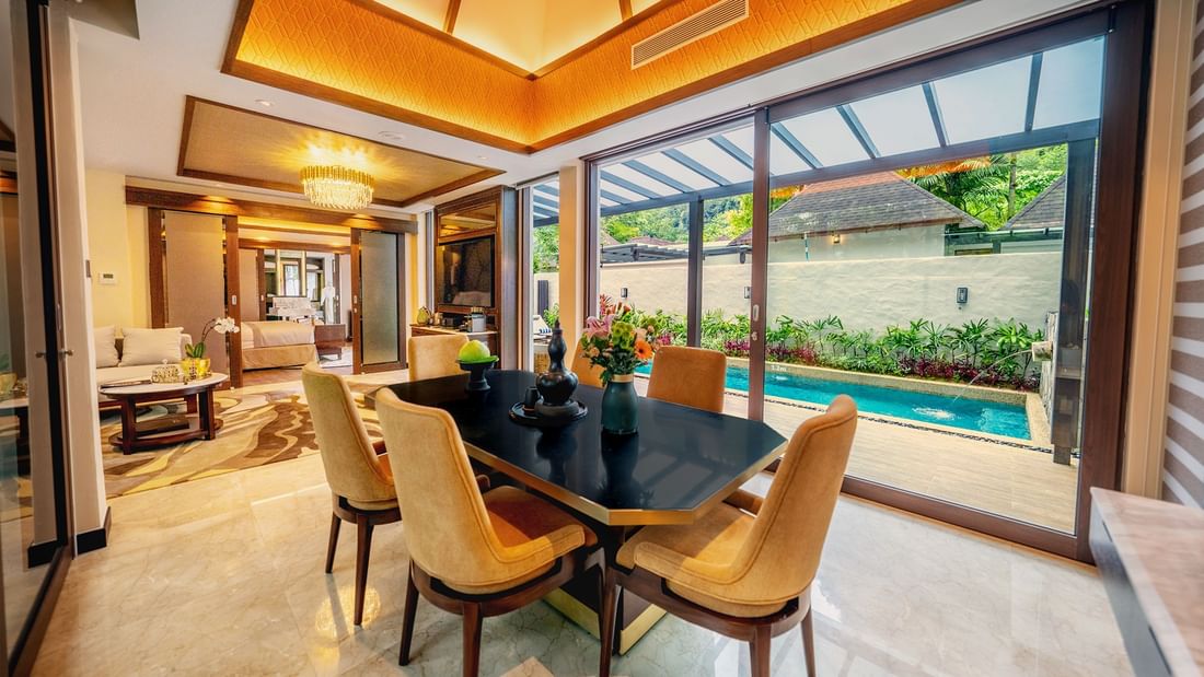 Luxurious dining area with a table, chairs, and a pool view through glass doors promoting ultra-luxury festive stay package