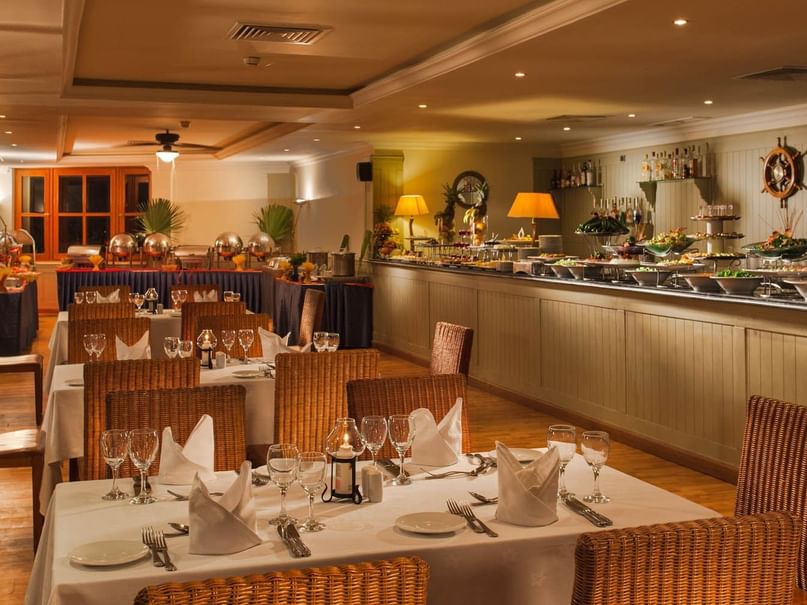 Wasabi restaurant with wicker chairs, set tables, & buffet display of food and drinks at Pickalbatros Golf Beach Resort