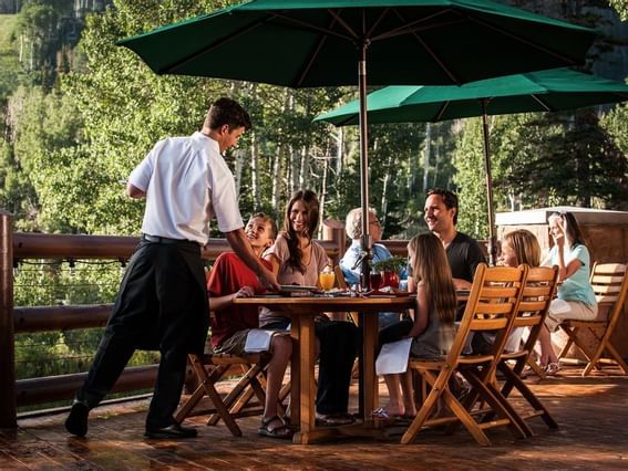 A waiter serves a family at an outdoor patio in Stein Lodge
