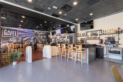 Interior view of The Gavel restaurant at The Riverwalk Plaza Hotel, featuring a bar with stools, decorative wall art