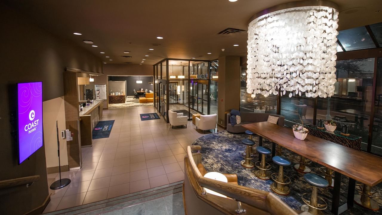 A spacious lobby with modern furniture and a large chandelier at Coast Bastion Hotel.