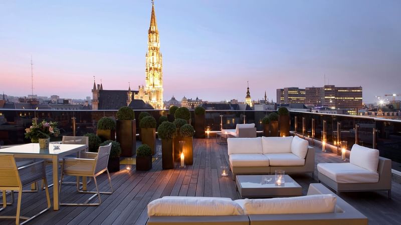 Grand Place Suite Terrace with seating area and city view at Warwick Brussels during night