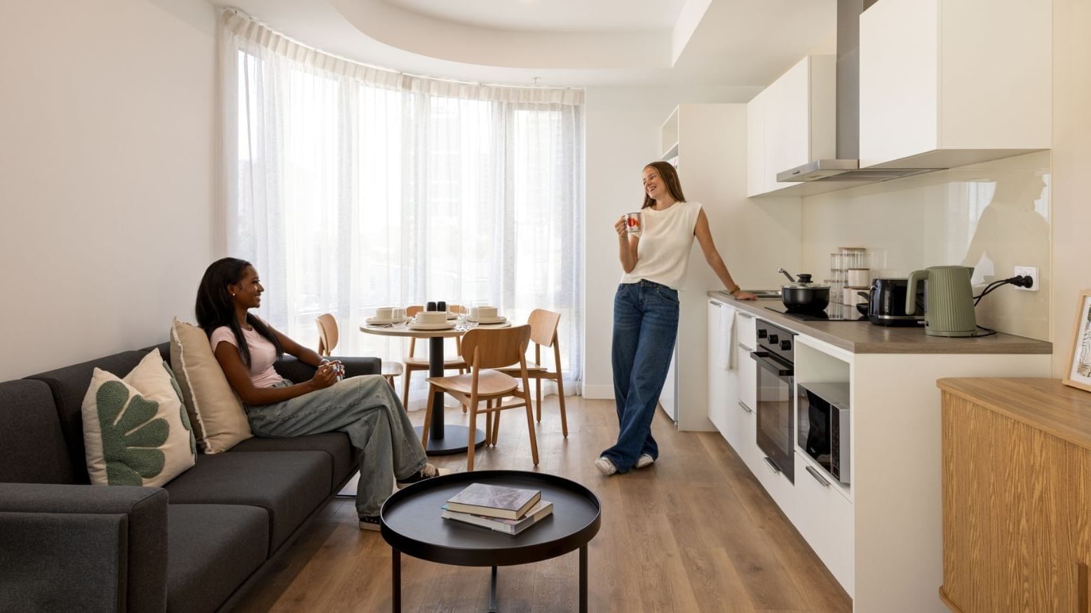 Two female students relaxing in a modern studio living space