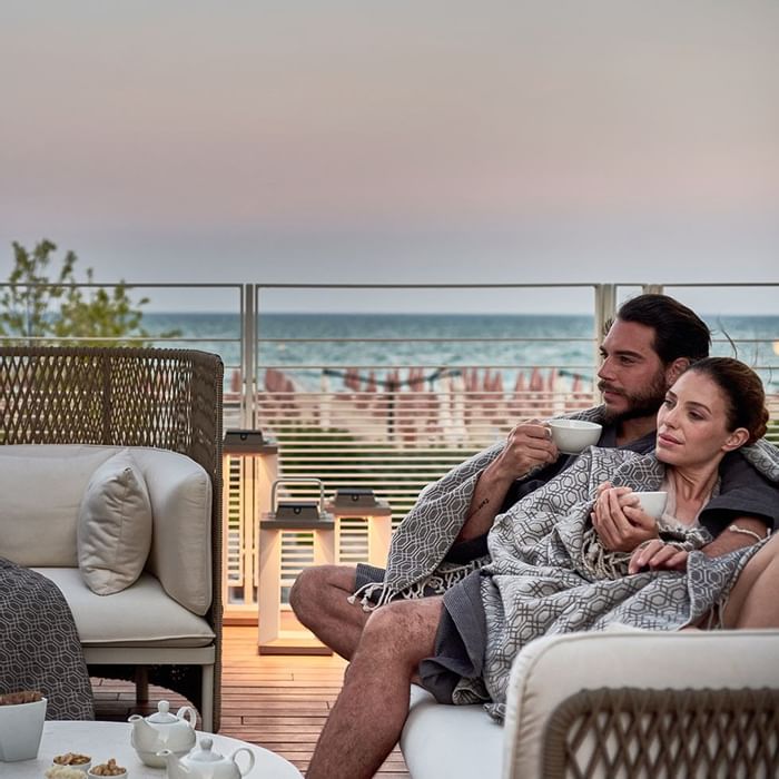 Couple enjoying tea by sea view balcony at Falkensteiner Jesolo