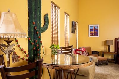 Dining table, comfy sofa & lamps in the living area of King Premiere Sante Fe at Retro Suites Hotel