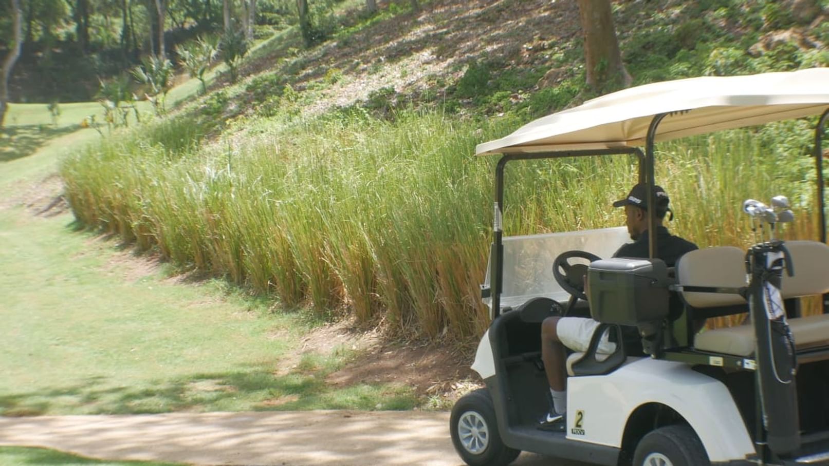 man driving golf cart on trail