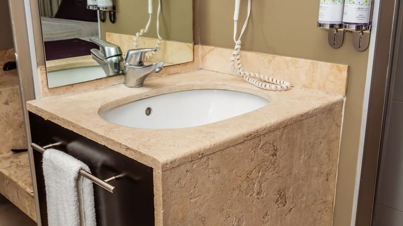 Bathroom vanity with amenities in a room at Gamma Puebla Senorial Centro