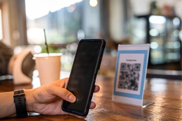 Phone scanning QR code promotion to sign up to event