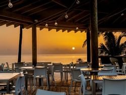 outdoor restaurant patio overlooking ocean and sunset