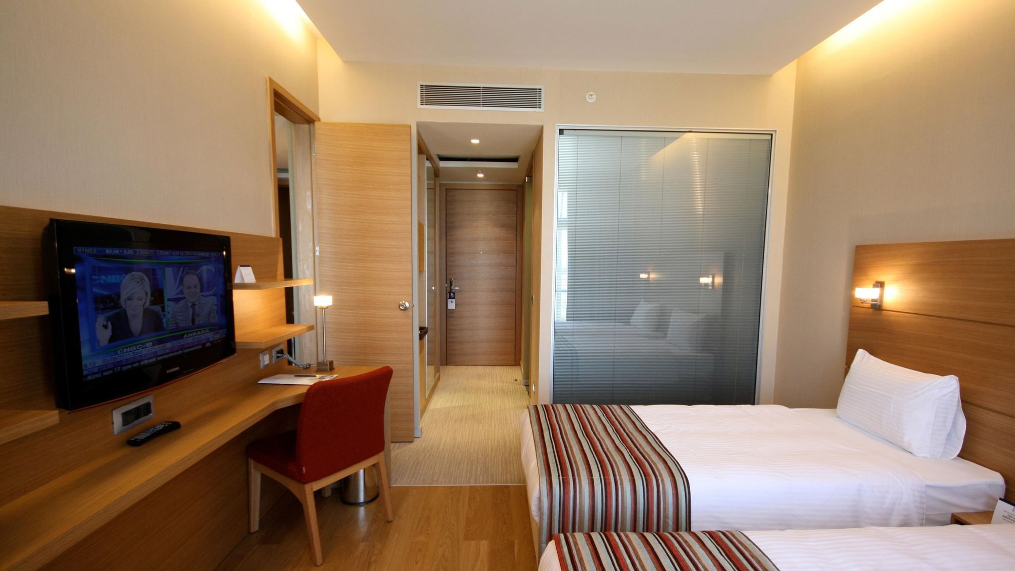 Superior Room with twin beds, desk, TV and a frosted glass bathroom door at Titanic Anadolu Gebze
