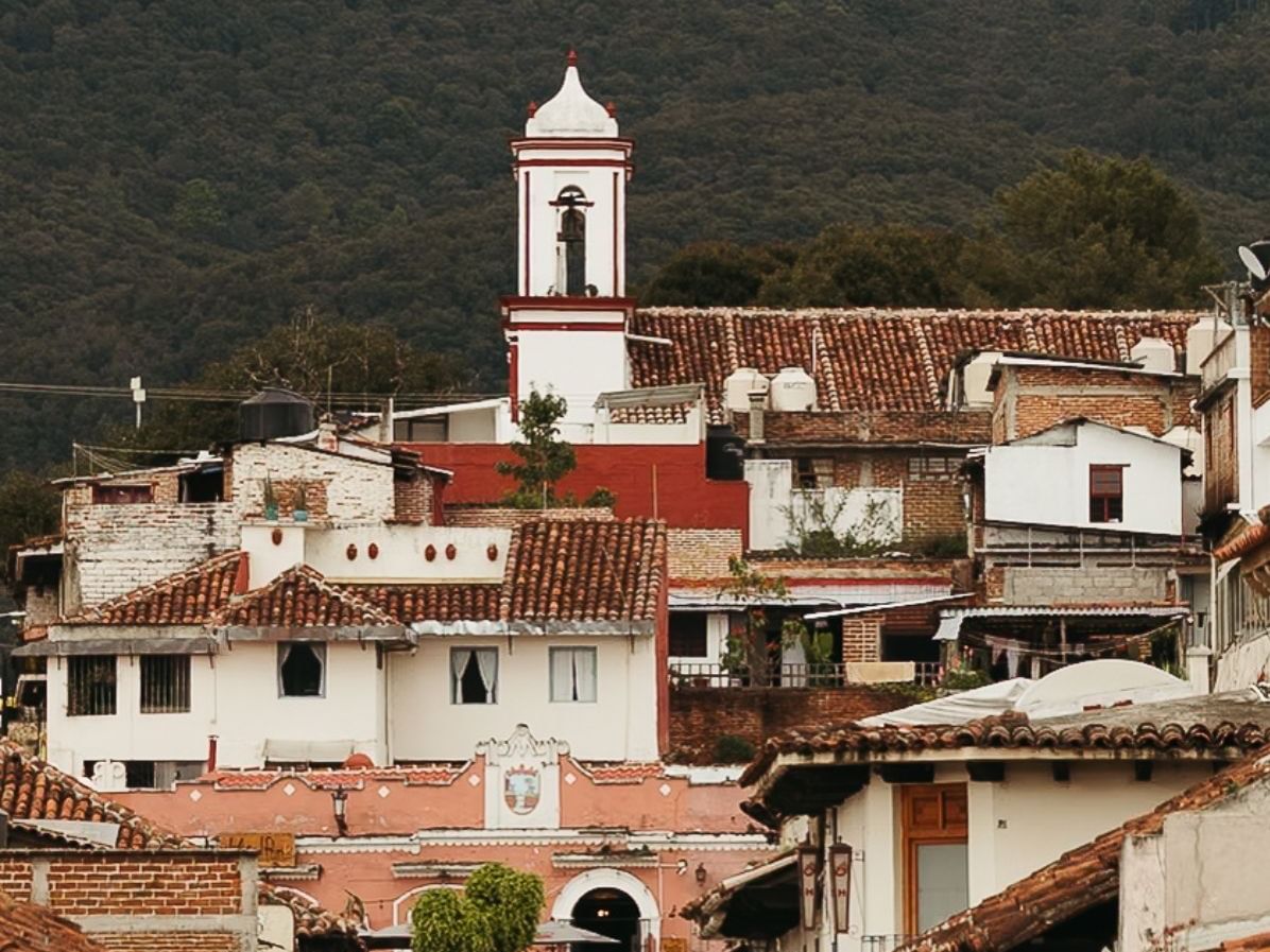 Paisaje urbano con casas coloniales y campanario destacado en oferta Verano Coleto