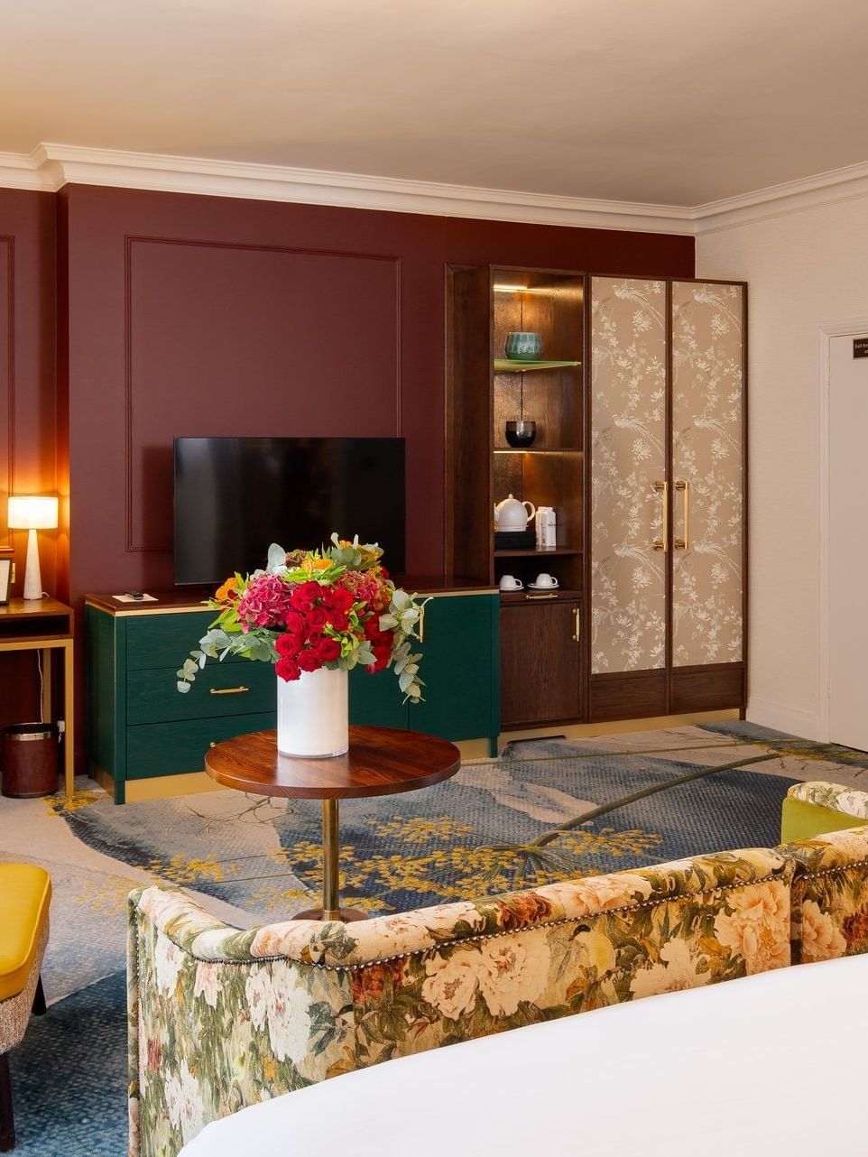 Deluxe King TV lounge with plush sofa and wood cupboard at The Capital Hotel, Apartments and Townhouse