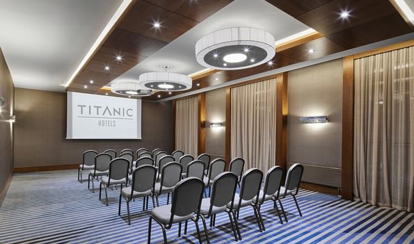 Konferenzraum Köln mit Stühlen und Bildschirm im Titanic Chaussee Berlin