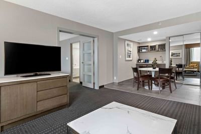 tv and dining table in hotel suite