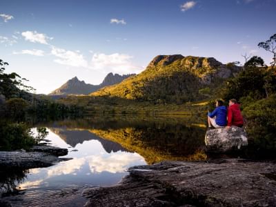 Couple sitting near Wombat Pool at Cradle Mountain Hotel