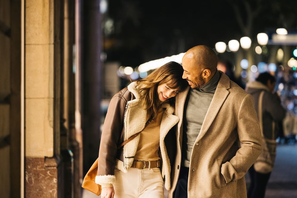 Couple walks together at night along a street at Warwick Allerton Chicago