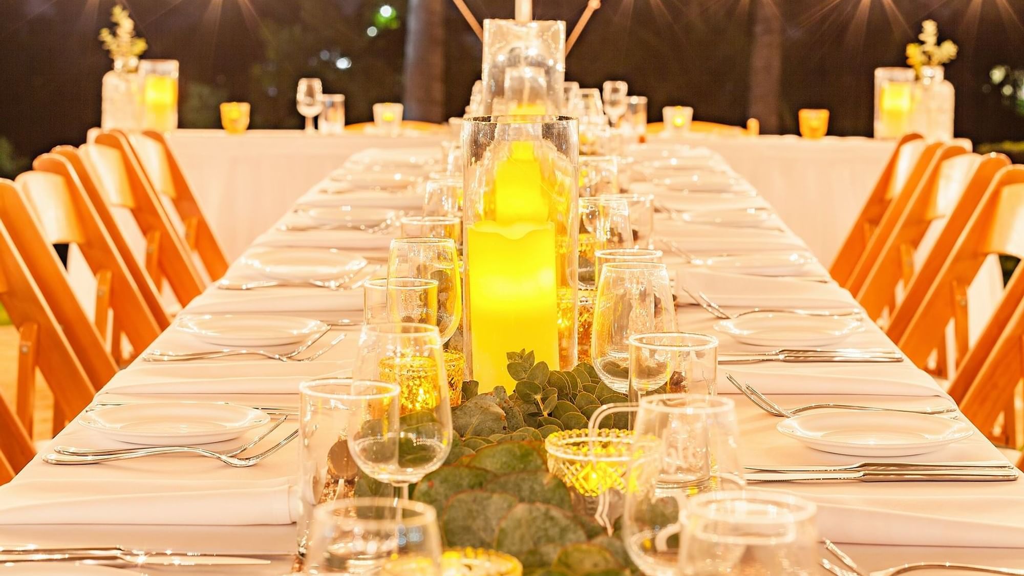 Well set dinner table under soft lights featuring candles, glassware, and greenery at Mercure Hotel Townsville