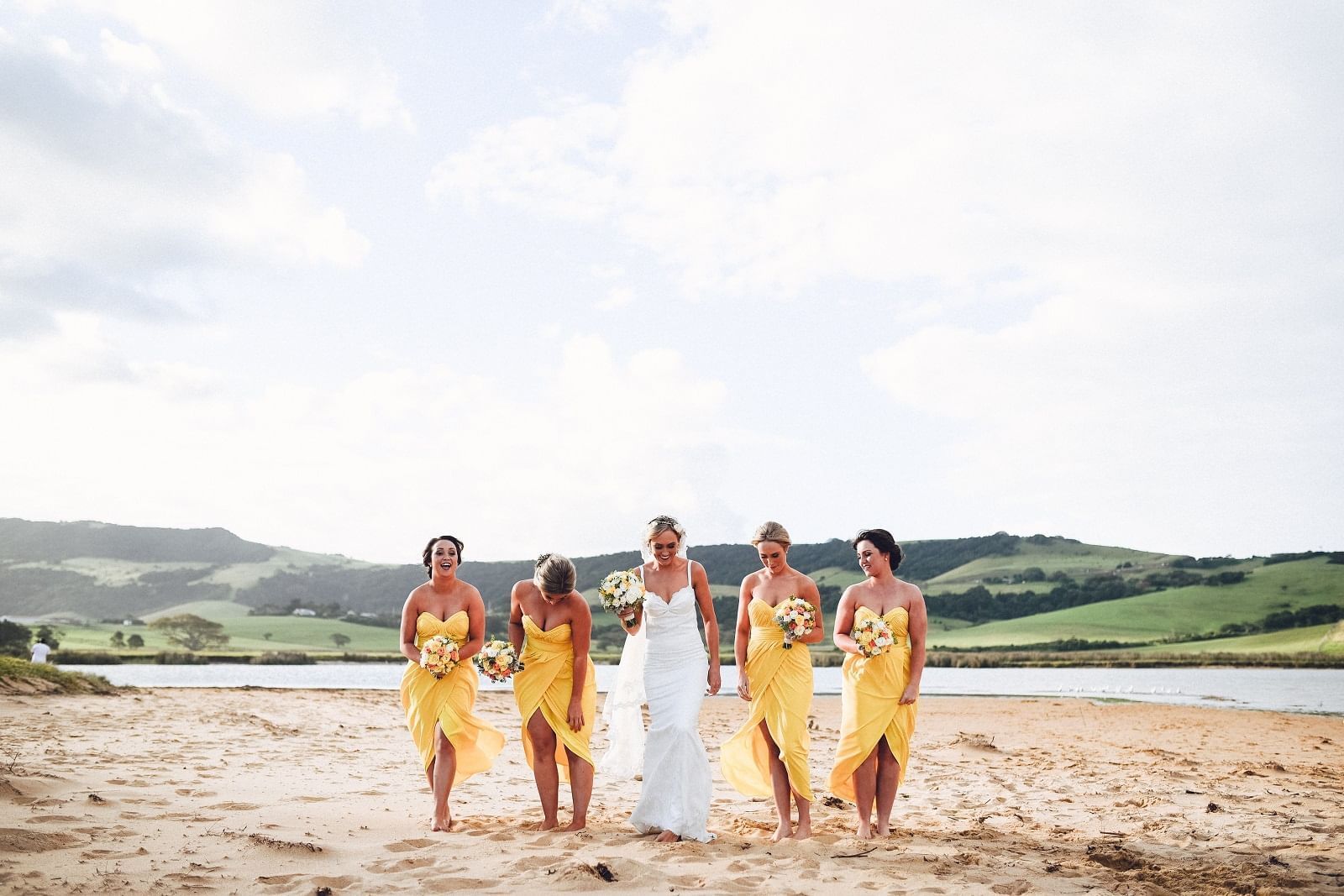 Bride and bridesmaids walking on beach at Mercure Gerringong