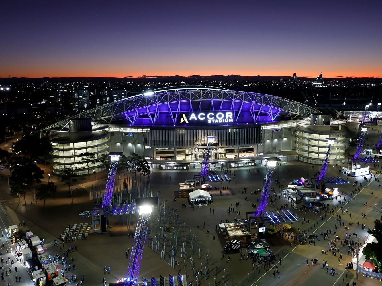 Aerial view of illuminated Accor Stadium near Nesuto Hotels