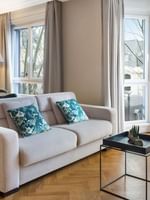 Dining table by the living area with plush seating and outdoor views in the Premium Suite at Warwick Reine Astrid - Lyon