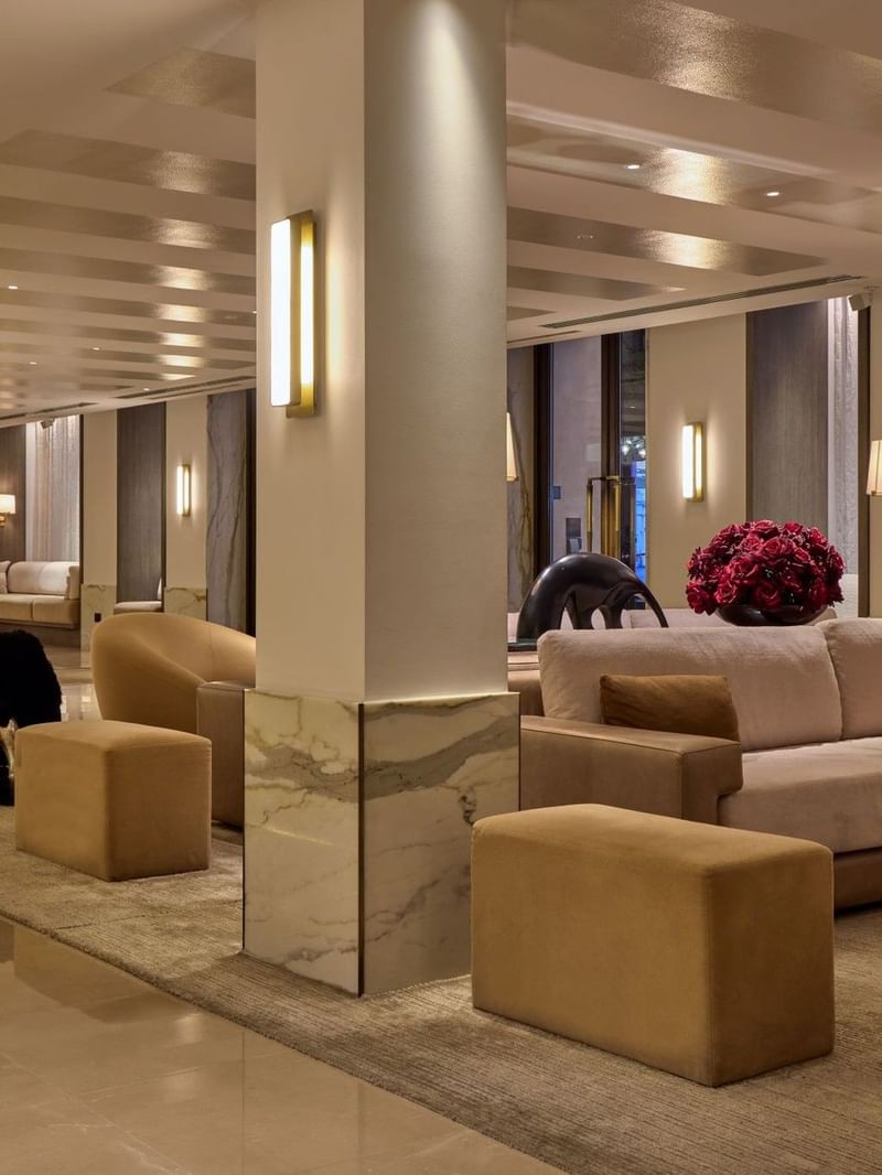 The May Fair Hotel lobby in London with elegant furniture, polished floors, and modern decor.