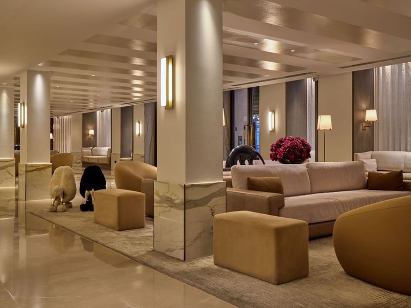 The May Fair Hotel lobby in London with elegant furniture, polished floors, and modern decor.