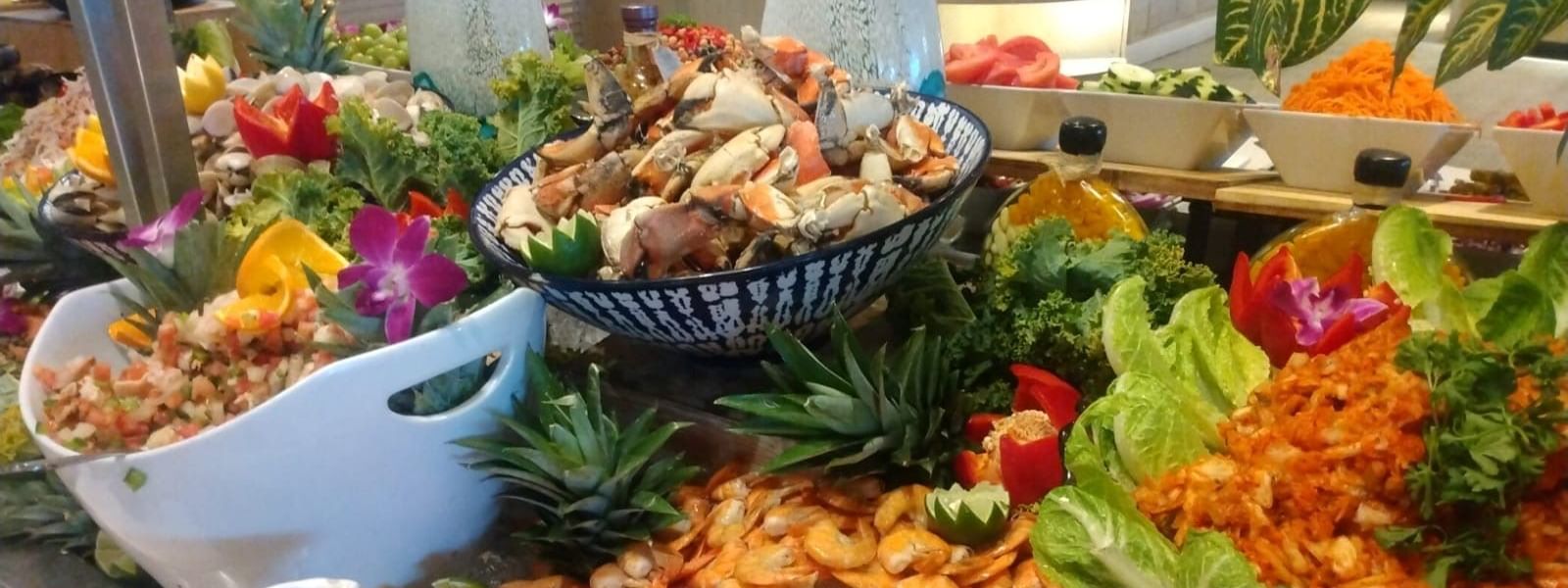 An array of seafood dishes including shrimp, crab, and various garnishes on a buffet table at Warwick Hotels and Resorts