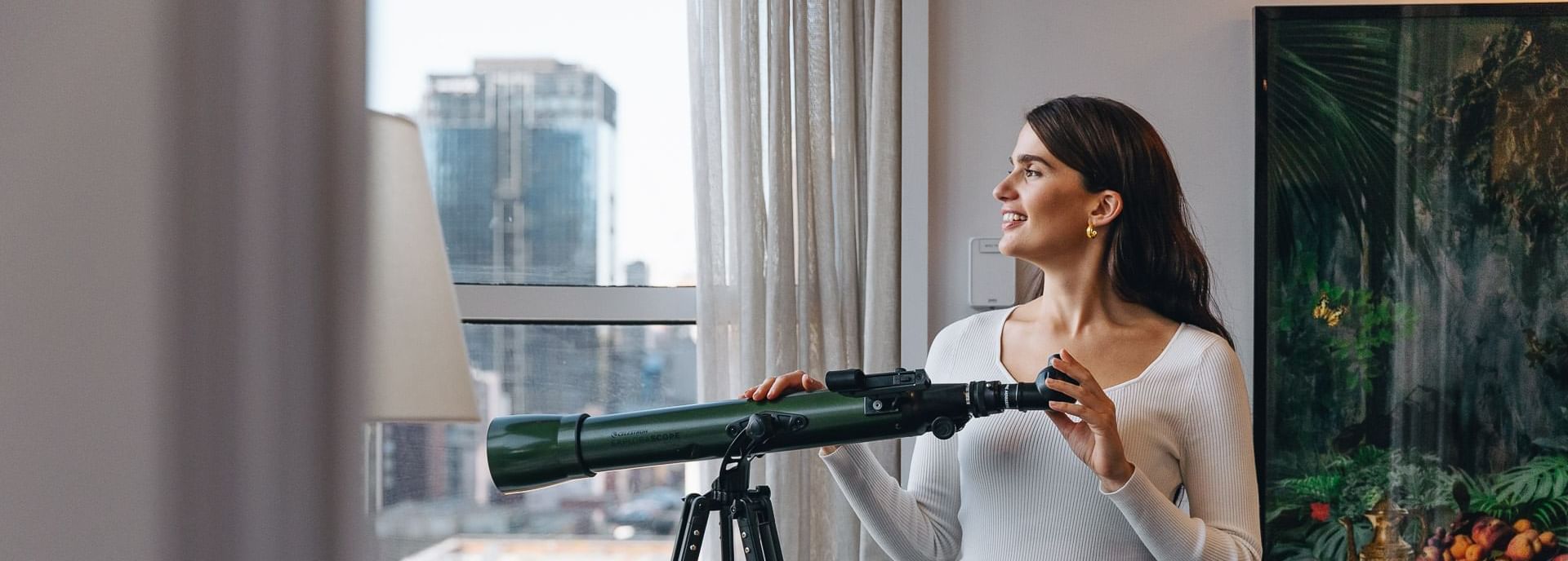 A woman holding a telescope at Pullman Melbourne City Centre