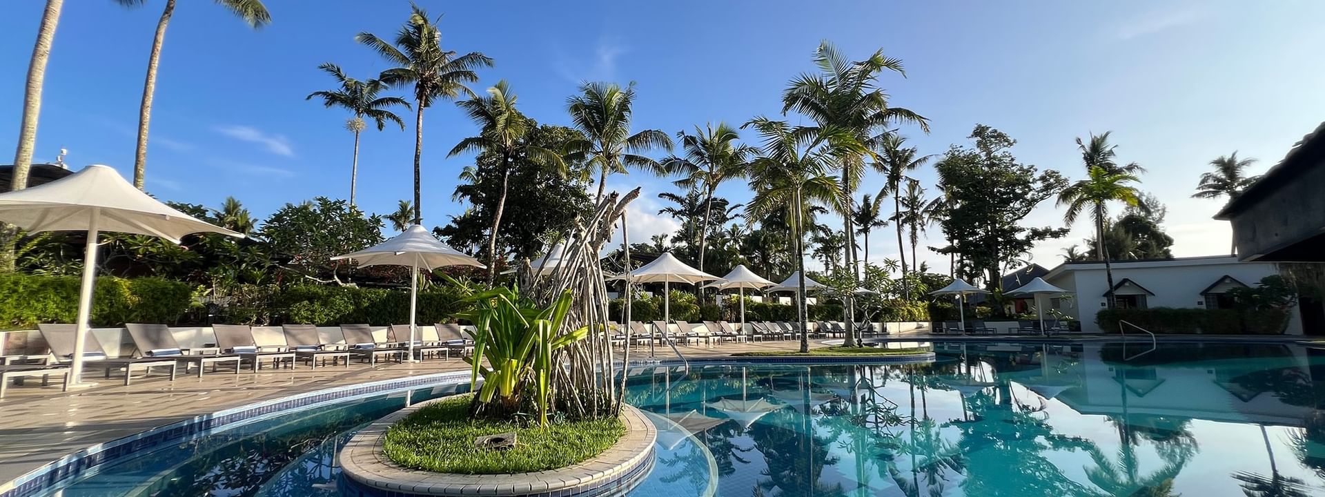 Pool and terrace beach area surrounded by palm trees at Warwick Le Lagon - Vanuatu in Efate