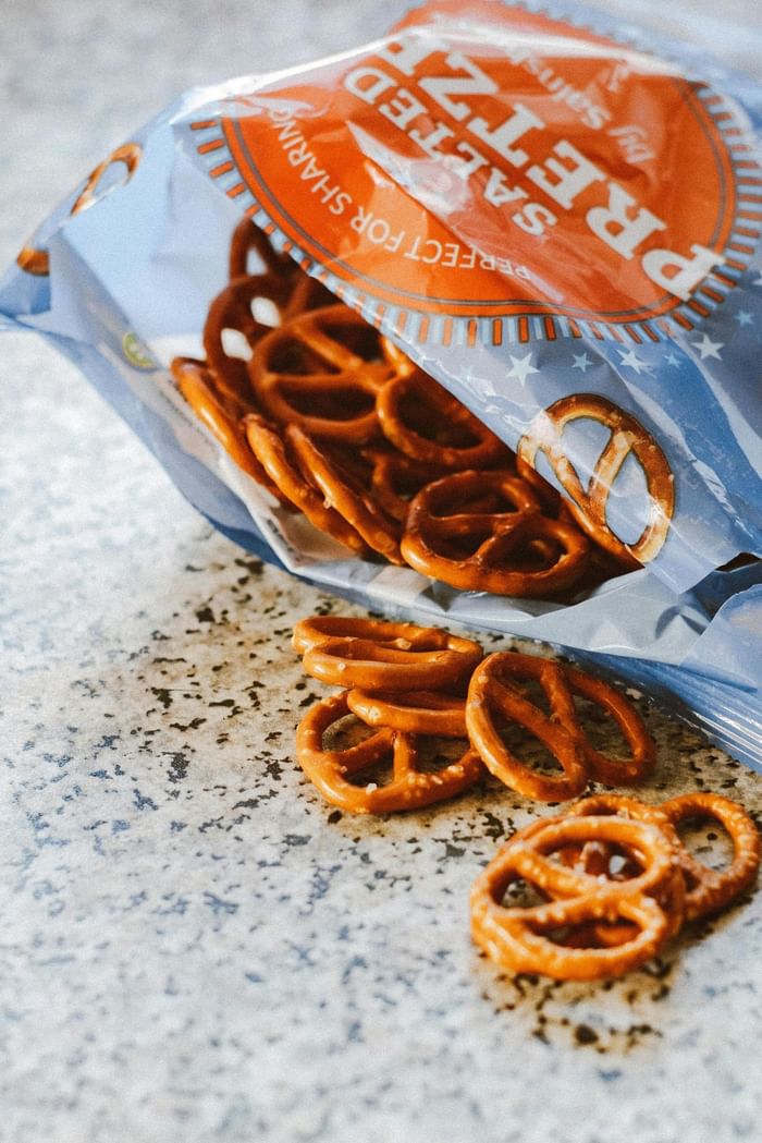 Salted pretzels spilling from a blue bag by a granite counter at the Anaheim Portofino Inn & Suites