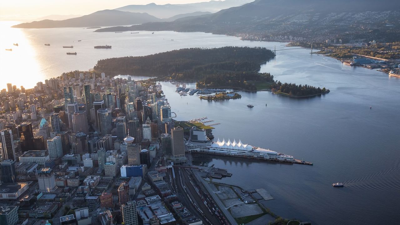 Aerial view of a city with a waterfront, white building and mountains in the distance near Coast Lonsdale Quay Hotel 