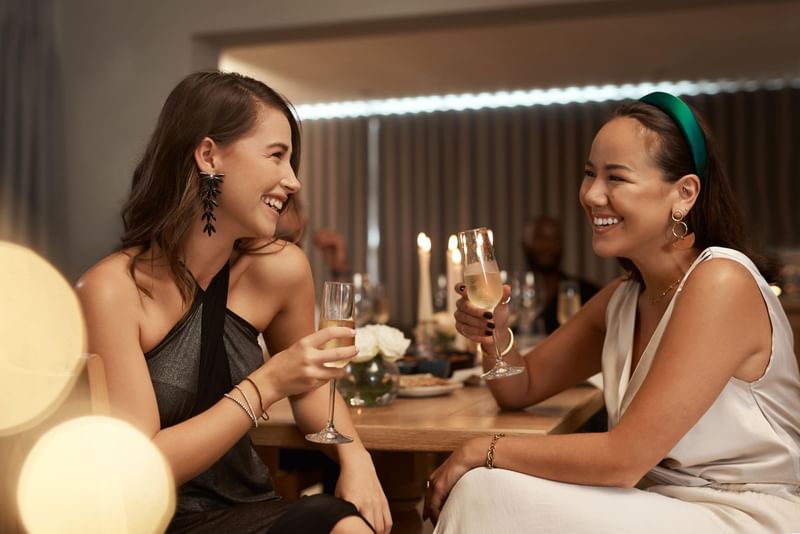 Two people toasting with wine glasses at a gathering in Diplomat Beach Resort