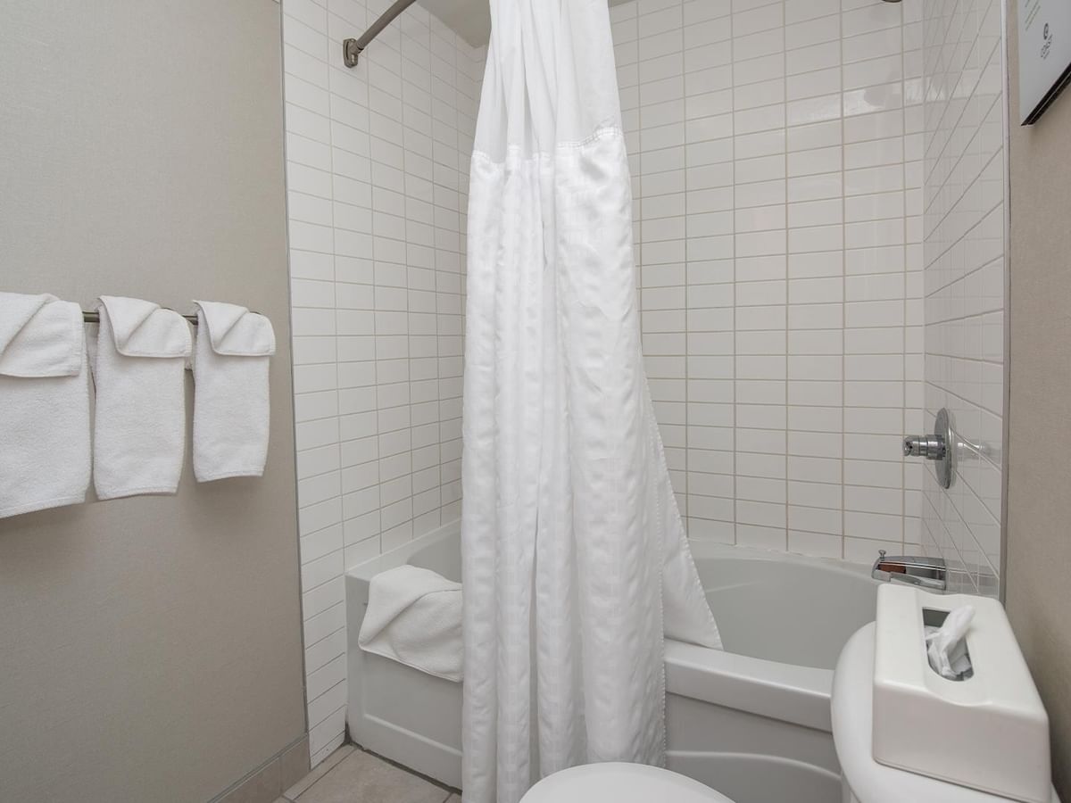 Bathroom with bathtub, shower, toilet, and towels.