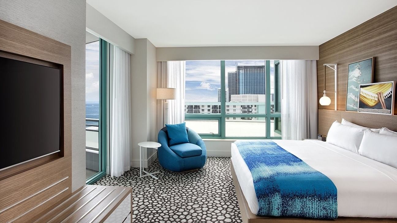 TV and lounger by the bed in Corner Ocean Suite at Diplomat Beach Resort