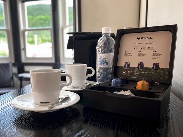 Nespresso coffee capsules, machine and cups on a table at Midnight Sun, a Coast Hotel