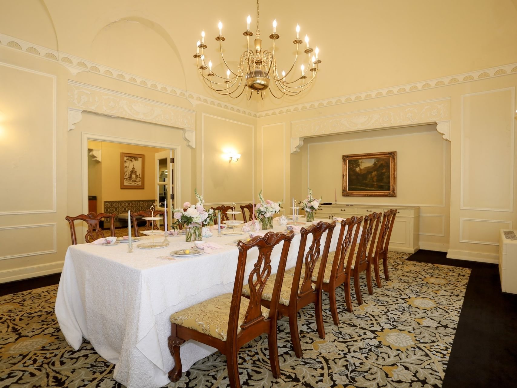 Formal Boardroom with a white tablecloth, floral carpet and gold chandelier at Arlington Resort Hotel & Spa