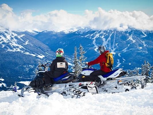 People snowmobiling near Aava Whistler Hotel