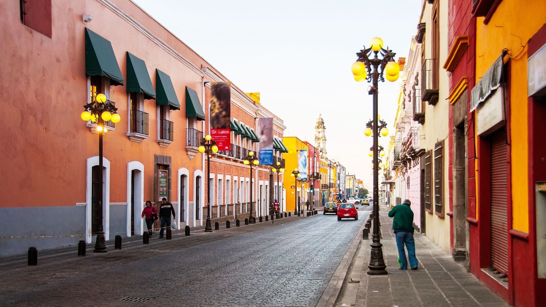 Colonial buildings lining a cobblestone street with ornate lamps in the Centro Histórico de Puebla near Quinta Real Puebla