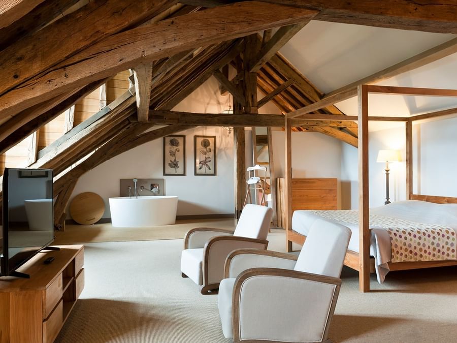 Spacious bedroom with a lounge and a TV at Chateau de Perreux
