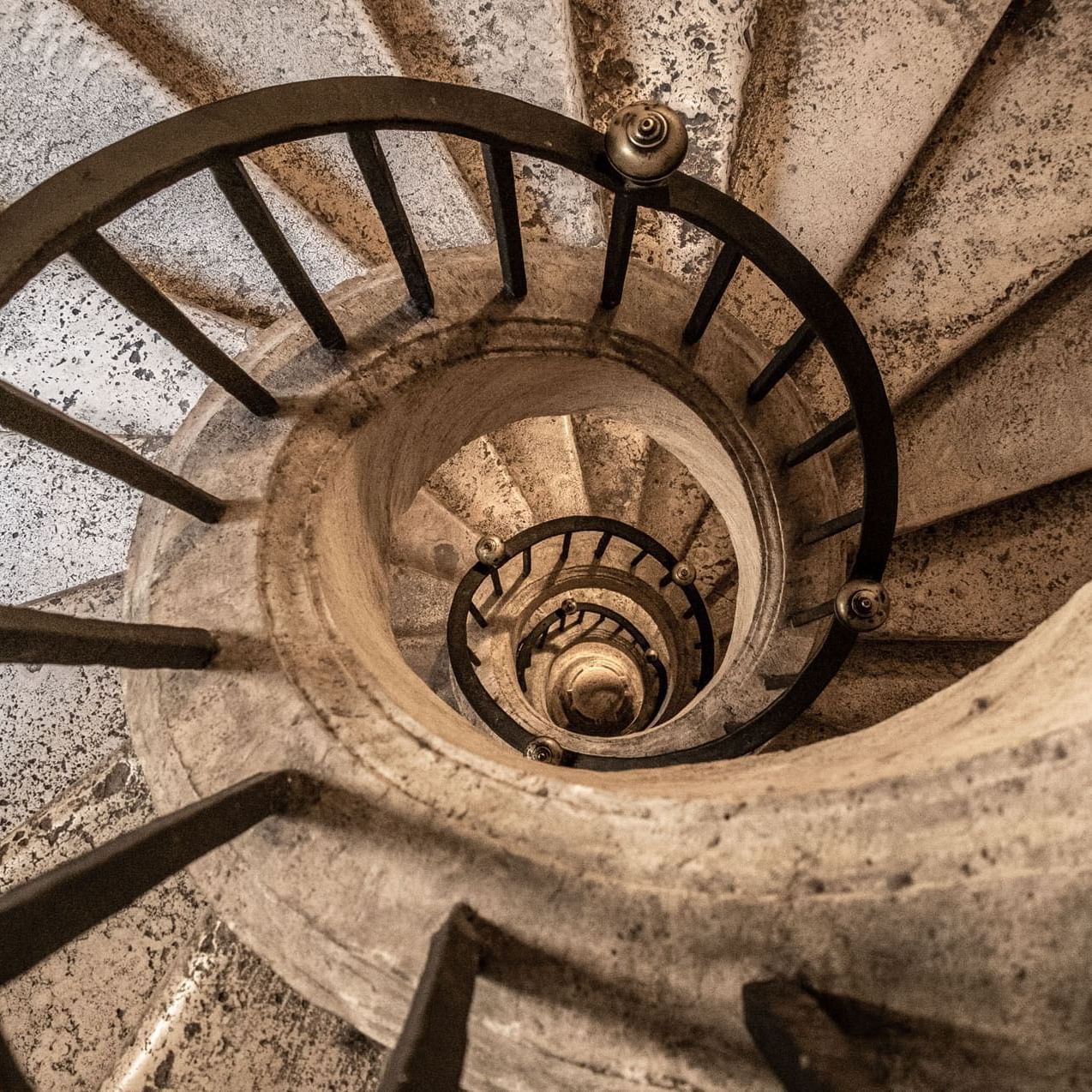 Top view of old snail-shaped stairs near Rome Luxury Suites