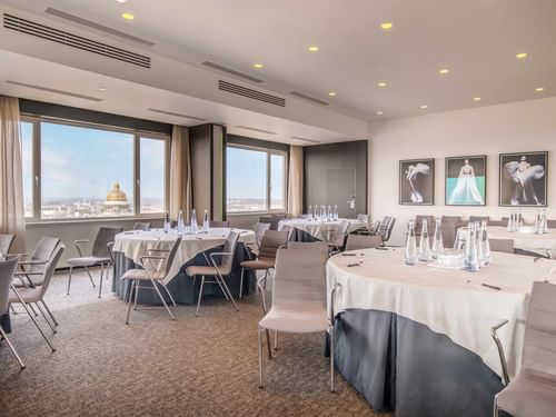 Vista 27 Meeting room with city view, tables set for event, and art on walls at The Hotel Brussels