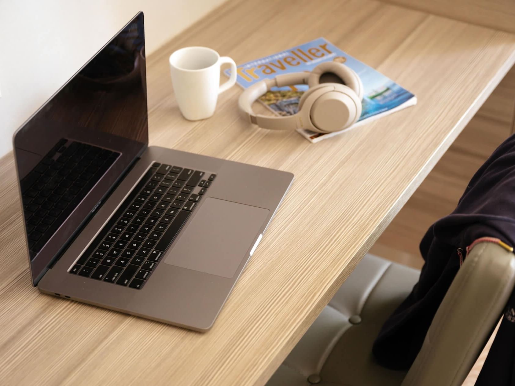 Headphones, magazine & mug by the laptop at Nesuto Hotels