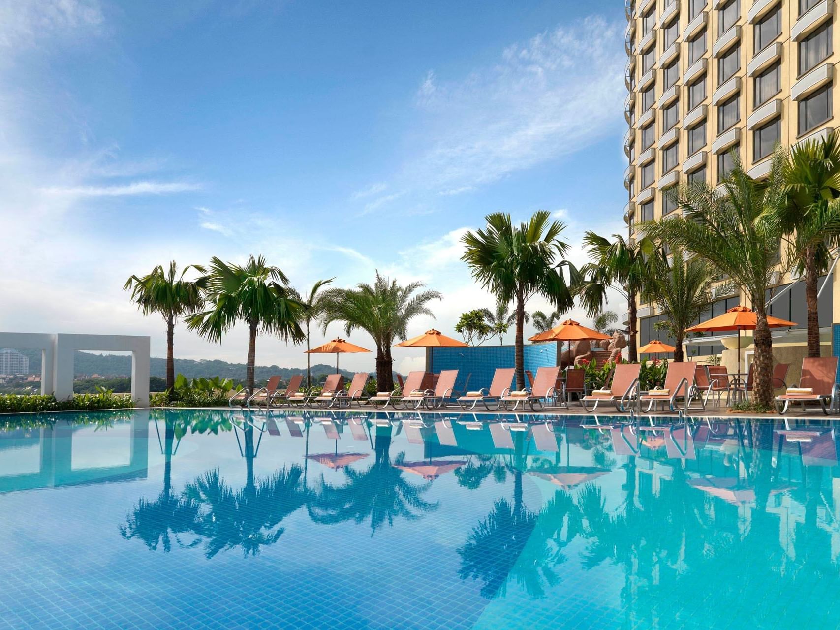 Landscape view of the hotel pool, palm trees & lounge chairs at One World Hotel