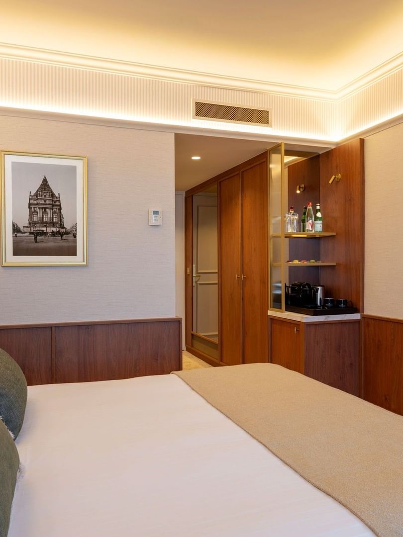 Superior Room with plush bedding, wood paneling, minibar, and flat-screen TV at Warwick Brussels Grand-Place